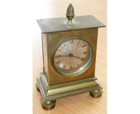 A 19th Century small brass Mantel Clock, the overhanging top surmounted with a pineapple finial above a textured silver dial 