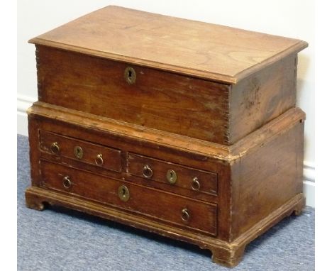 An 18th century Welsh elm Coffer Bach, the moulded hinged lid above an arrangement of two half-width and one single further f