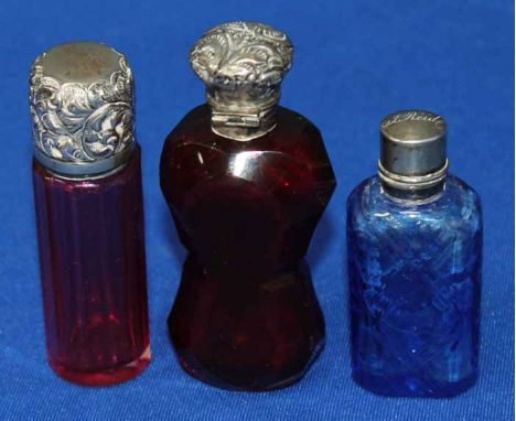 GROUP OF THREE SILVER MOUNTED SCENT BOTTLES
one in ruby, one in cranberry and one in blue,  7-8cm high (3) 