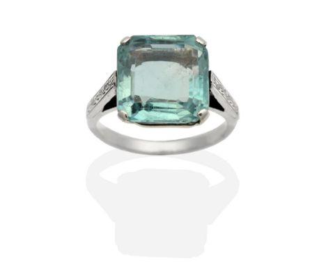 An Early 20th Century Aquamarine Ring, a square octagonal cut aquamarine in a claw setting, to chased shoulders, finger size 