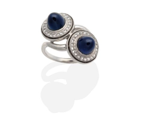 An Art Deco Sapphire and Diamond Ring, two high dome cabochon sapphires in milgrain settings within single-cut diamond set ci