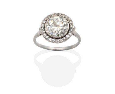 An Art Deco Diamond Cluster Ring, an old cut diamond in a milgrain setting within a border of old cut diamonds, to knife edge