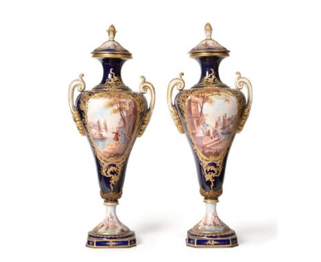 A Pair of Sèvres Style Pottery Urn Shaped Vases and Covers, circa 1900, with pine cone finials and scroll handles, decorated 