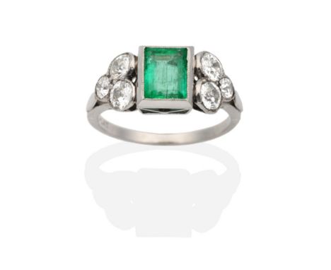 An Art Deco Emerald and Diamond Ring, a baguette cut emerald in a rubbed over setting, spaced by old cut diamonds in milgrain