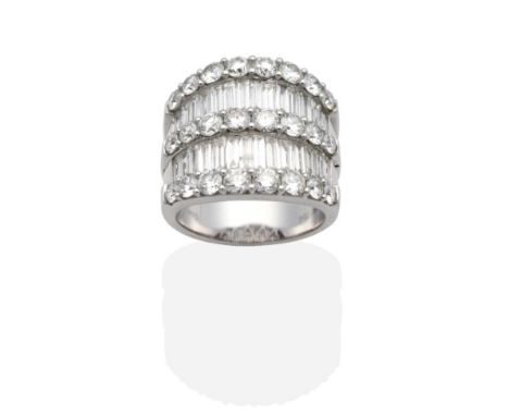 A Diamond Ring, three slightly graduated bands of round brilliant cut diamonds in claw settings between two bands of channel 