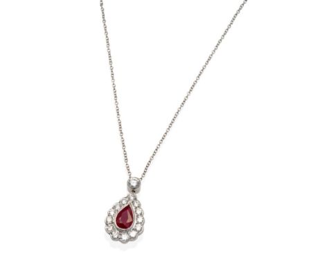 A Ruby and Diamond Pendant, on Chain, a round brilliant cut diamond in a milgrain setting suspends a pear cut ruby within a b