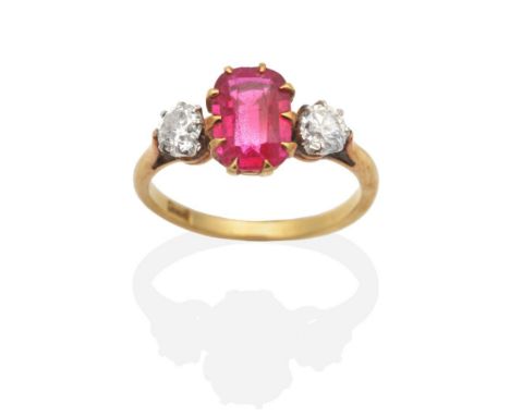 A Ruby and Diamond Three Stone Ring, a rectangular cushion cut ruby in a claw setting, between old cut diamonds, to knife edg