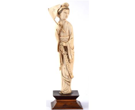 A Japanese Ivory Okimono, Meiji period, as a female samurai carrying the flag of the Black Flag Army, wearing flowing robes, 