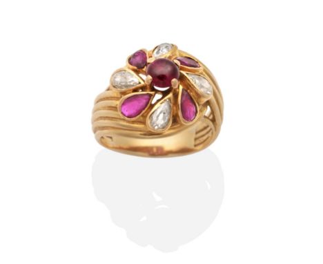 A French Ruby and Diamond Cluster Ring, a round cabochon ruby in a claw setting, within a border of pear cut rubies and diamo