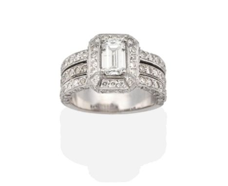 A Diamond Ring, an octagonal cut diamond in a claw setting, within a conforming round brilliant cut diamond frame and diamond