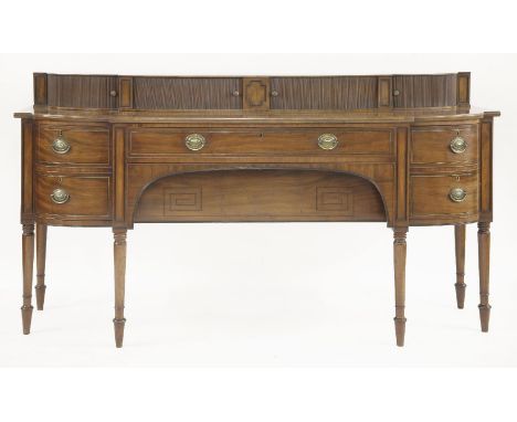 A Regency mahogany bow front sideboard,the top with tambour-fronted cupboards over two long drawers flanked by a cellaret dra