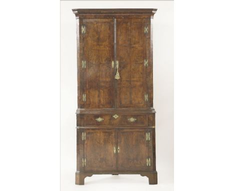 A walnut and feather banded corner cupboard,18th century, in two parts, the upper section opening to reveal a green painted i