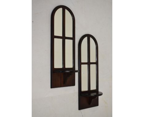 Pair of mahogany-finished console mirrors, each of arched design with shelf, each 66cm high  