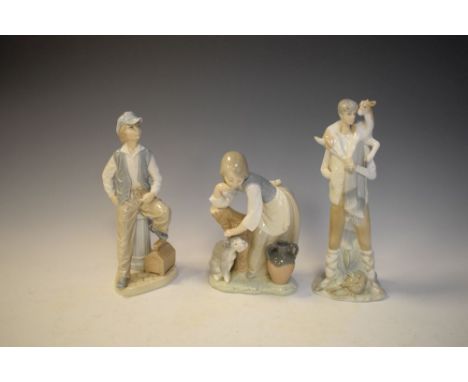 Two Lladro figures and a Nao figure of a boy seated on a fire hydrant, the tallest 28cm high  