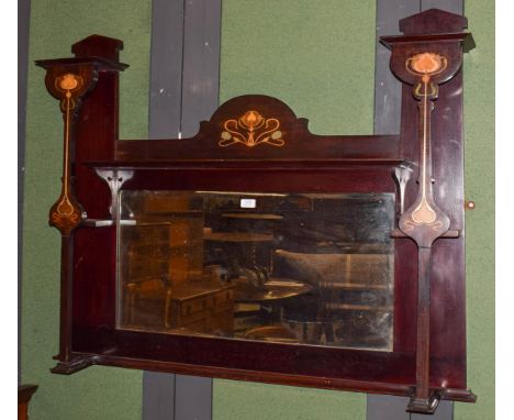 An Art Nouveau inlaid stained beech over mantel mirror, the bevel edged rectangular mirror with a shelf above, enclosed by tw