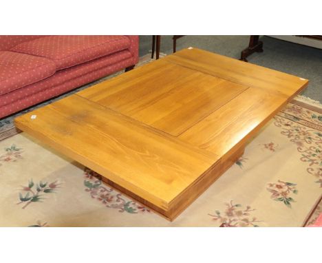 A modern light oak pedestal coffee table with central sliding compartment 140cm by 85cm by 45cm