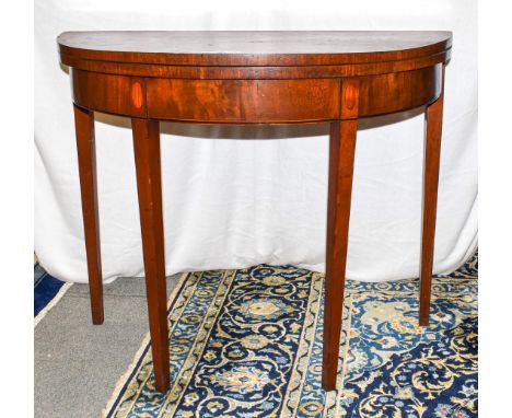 A George III crossbanded mahogany demi lune fold over card table, 90cm by 45cm by 74cm