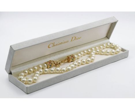 Kunstperlenkette, Christian Dior. Cremefarbene Kunstperlen mit roséfarbenem Lüster, D. ca. 10 mm, einzeln geknotet. Endkappen