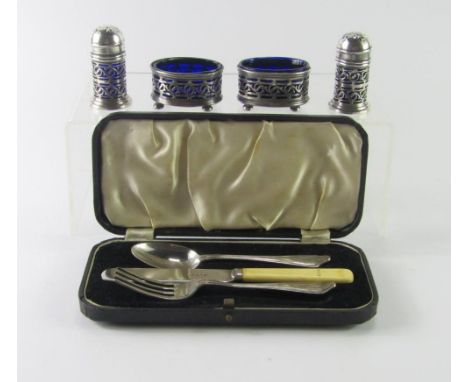 A George V silver four piece condiment set, with pierced foliate scroll decoration, blue glass liners, Chester 1919, and a kn