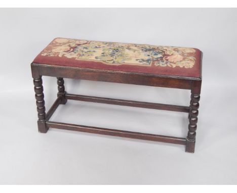 An oak duet stool, with woolwork top, bobbin turned legs, 96cm x 37cm.