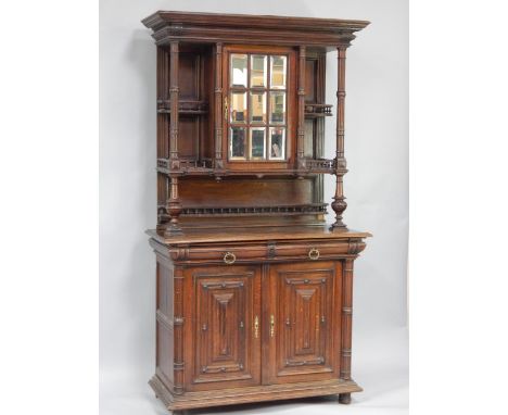 A French late 19thC oak buffet, the top with an outswept pediment over a bevelled glass multi panelled door flanked by shelve