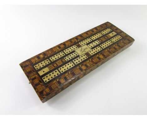 A Victorian masonic tunbridge ware and bone inlaid cribbage board, raised on four brass feet, 30cm x 11cm.