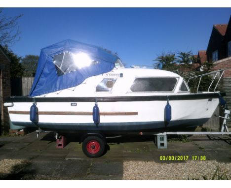 A Norman boat with Sprite trailer,  Johnson engine, trailer has spare wheel.