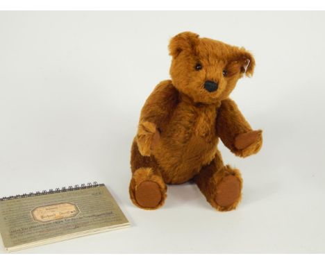 A Steiff replica of a traditional 1902 teddy bear, together with a blanket illustrating Richard Steiff's sketchbook.