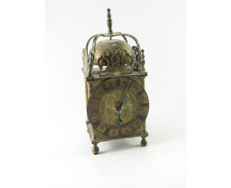 A brass early 20thC lantern clock, foliate engraved dial, chapter ring bearing Roman numerals, Empire movement, 10cm x 10cm x