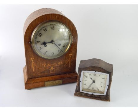An early 20thC oak and inlaid mantel clock, of domed form, silvered dial bearing Arabic numerals, eight day movement with sin