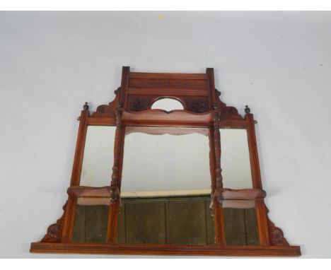 A Victorian mahogany overmantel mirror, the carved top with oval mirror inset, over five retangular mirrors and a three shelf