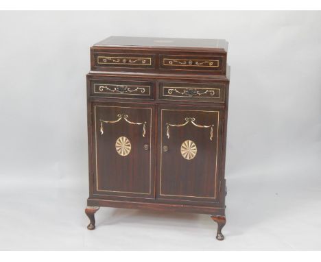 A Georgian style mahogany cupboard, with faux paterae, swag, scroll and line inlay decoration, four short drawers above cupbo