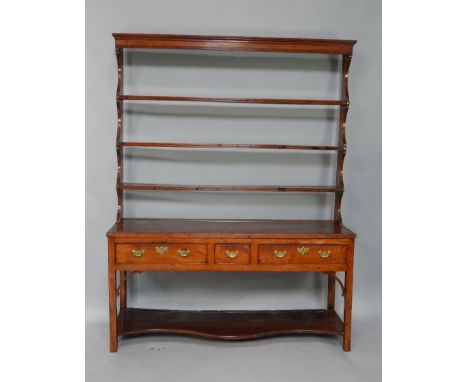 A George III oak and elm dresser, the three shelf delft rack over one short and two long frieze drawers, raised on square leg