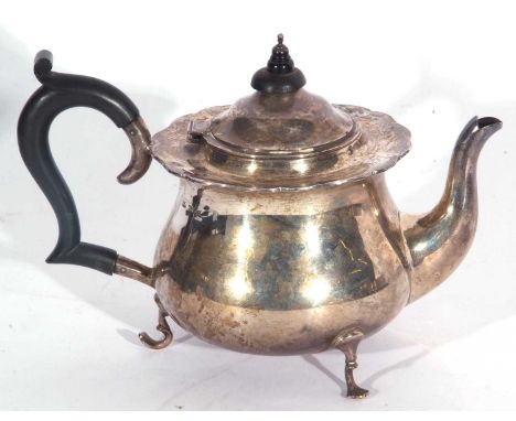 George V teapot of circular baluster form with shaped rim, ebonised handle and finial, supported on three curved feet, 17cm t