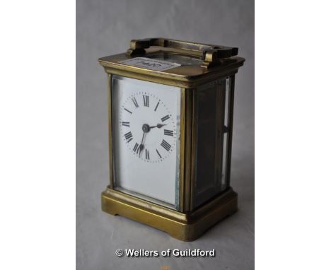 A brass carriage clock , the white enamel dial with Roman numerals, 10.75cm excluding handle.