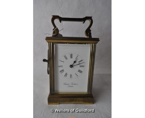 A brass carriage clock, white enamel dial Charles Frodsham, London, with key.