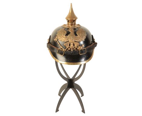 A WWI GERMAN PICKELHAUBE the leather skull with original leather lining and leather chin strap, brass spike top and pressed b