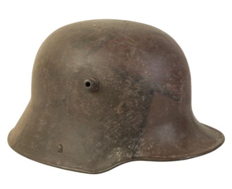 A WWI GERMAN CAMOUFLAGE HELMET with the original leather lining, stamped to the interior "BF64"