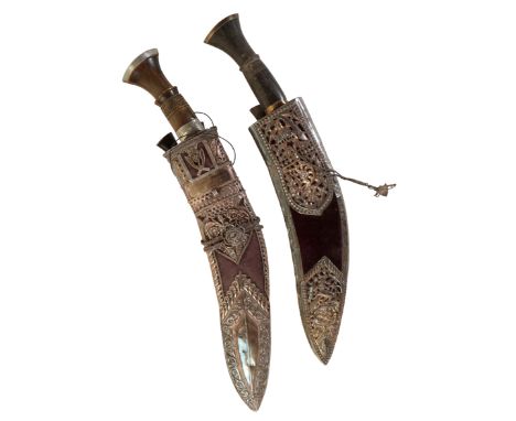 A GURKHA KUKRI KNIFE with an iron-mounted horn hilt, in a white metal floral decorated sheath, inscribed "Presented by The Qu