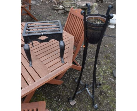 A CAST IRON TRIVET, along with a wrought iron strap work plant stand with a glazed planter, height 117cm (2)