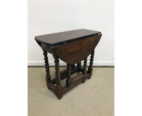 An 18th Century oak oval gate-leg drop-leaf tea table, on barley-twist supports united by stretchers, 107 cm wide x 77 cm dee