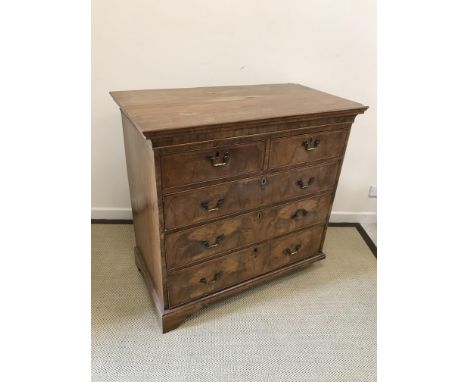 An 18th Century walnut chest, the plain top above two short and three long cross banded drawers with brass swan neck handles 