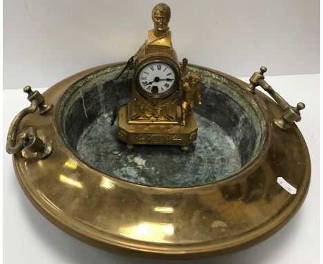 A 19th Century French lacquered brass cased mantle clock with circular enamel dial and Roman numerals surmounted by a bust of