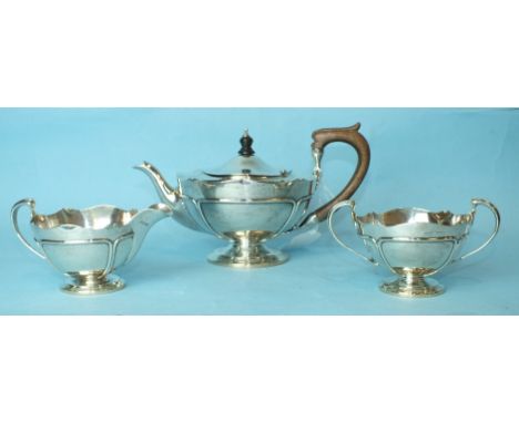 A silver three-piece tea service, each piece with wavy rim and circular pedestal base, maker Robert Pringle, London 1910, tot