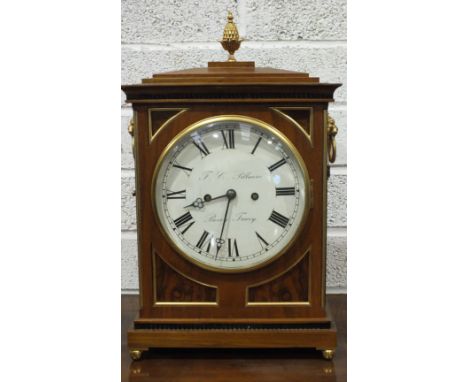 A Regency-style walnut bracket clock, the rectangular architectural form with gilt metal pineapple finial and lion mask handl