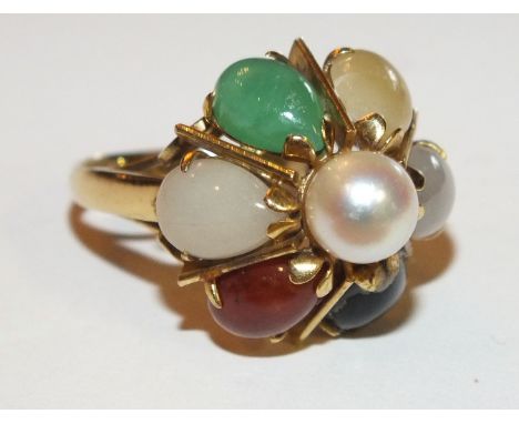 A 14k gold dress ring set seven different shades of jade radiating out from a central pearl, size N, 6g.