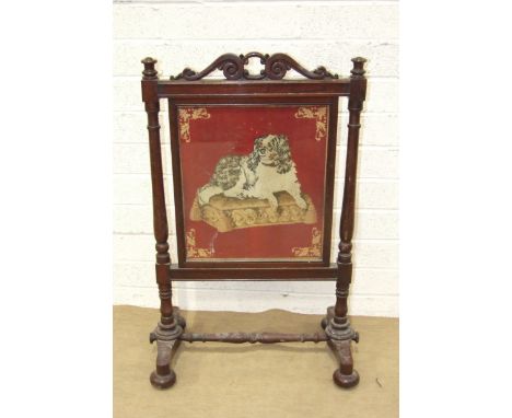 A William IV mahogany fire screen, the turned mahogany frame supporting a rectangular needlework panel depicting a King Charl