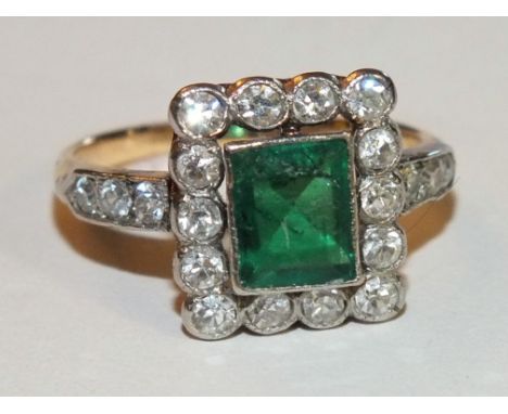 An emerald and diamond rectangular cluster ring, the collet set emerald, approximately 6.5 x 5.2mm within a border of fourtee