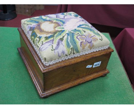A XIX Century Oak Footstool/Workbox, with later tapestry top and lift-up lid, on bun feet.