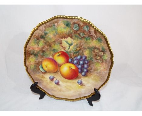 Royal Worcester - a cabinet plate hand painted with peaches and grapes to a mossy background, signed by H Ayrton, 27 cm diame